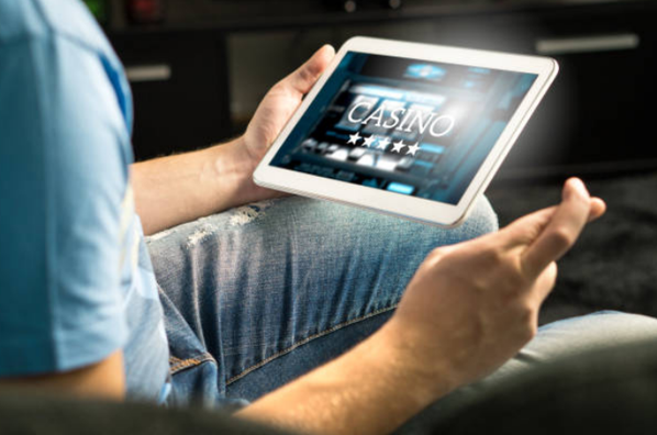 An excited man playing at an online casino on his ipad